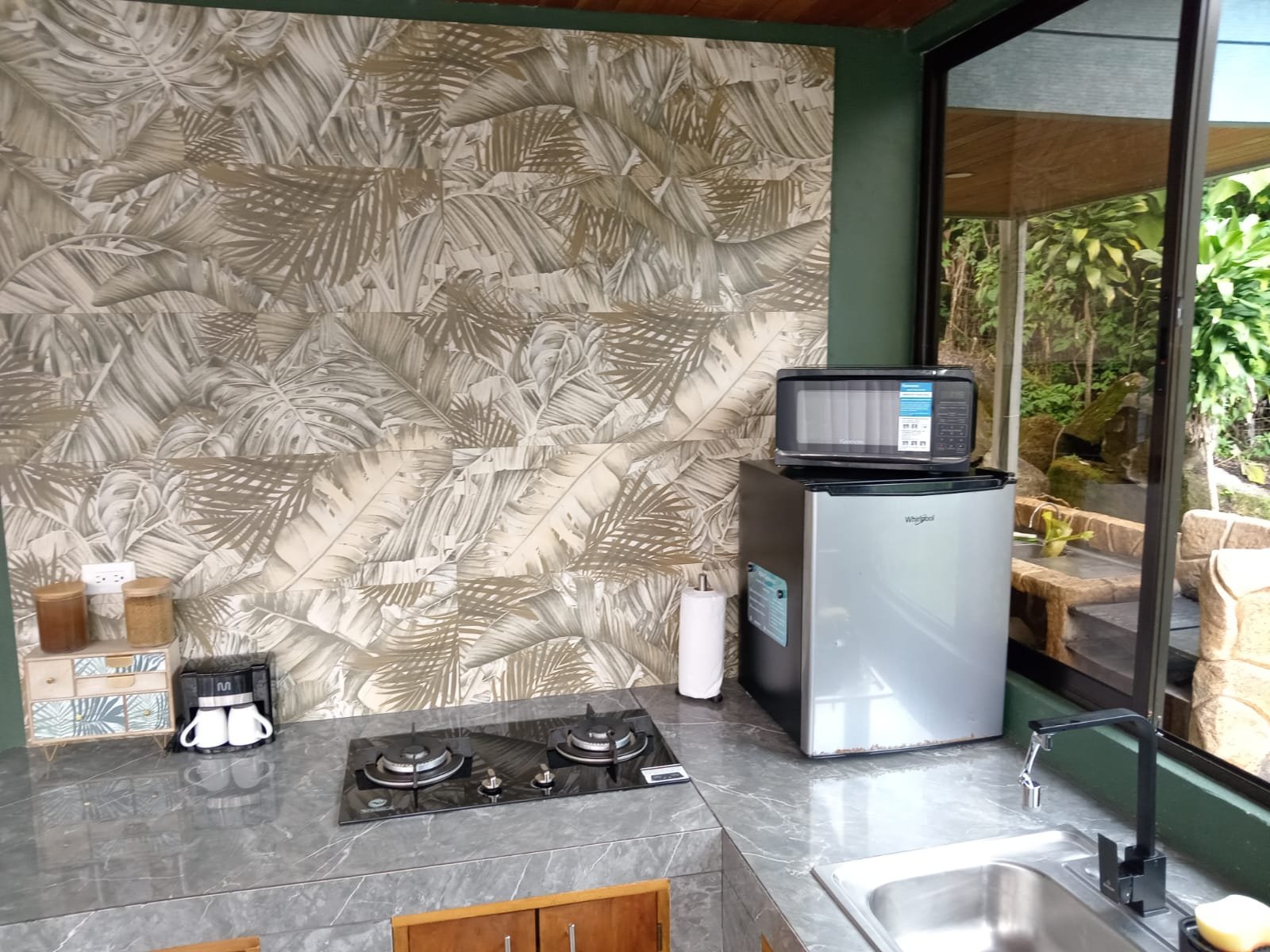 Cocina completa con estufa y refrigerador en hospedaje de Fraijanes, Alajuela