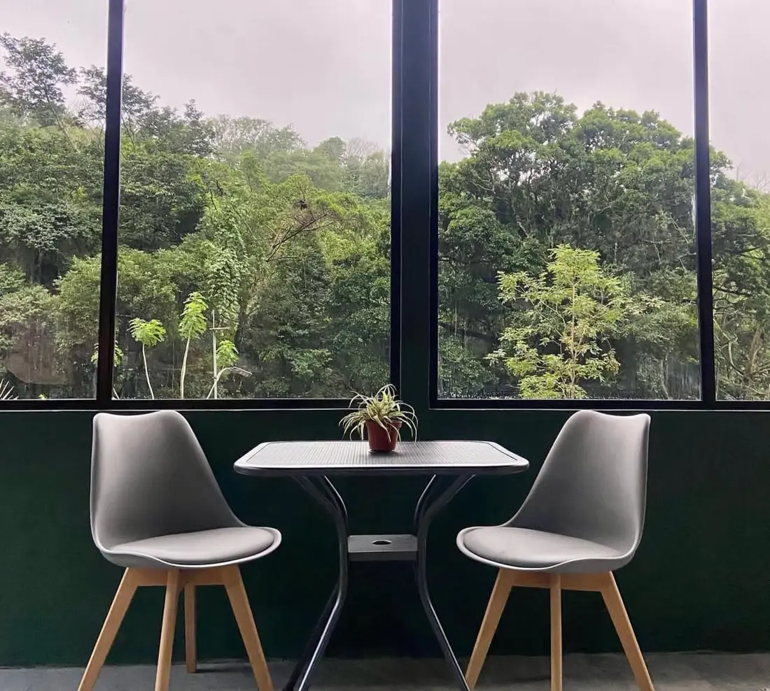 Sala con ventanales panorámicos hacia el bosque en la cabaña
